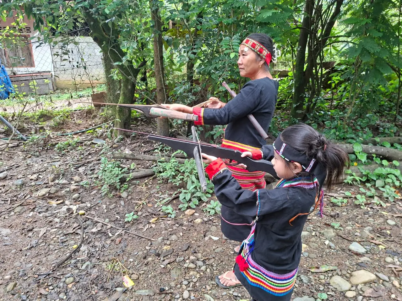 Khmu woman and girl practicing traditional archery