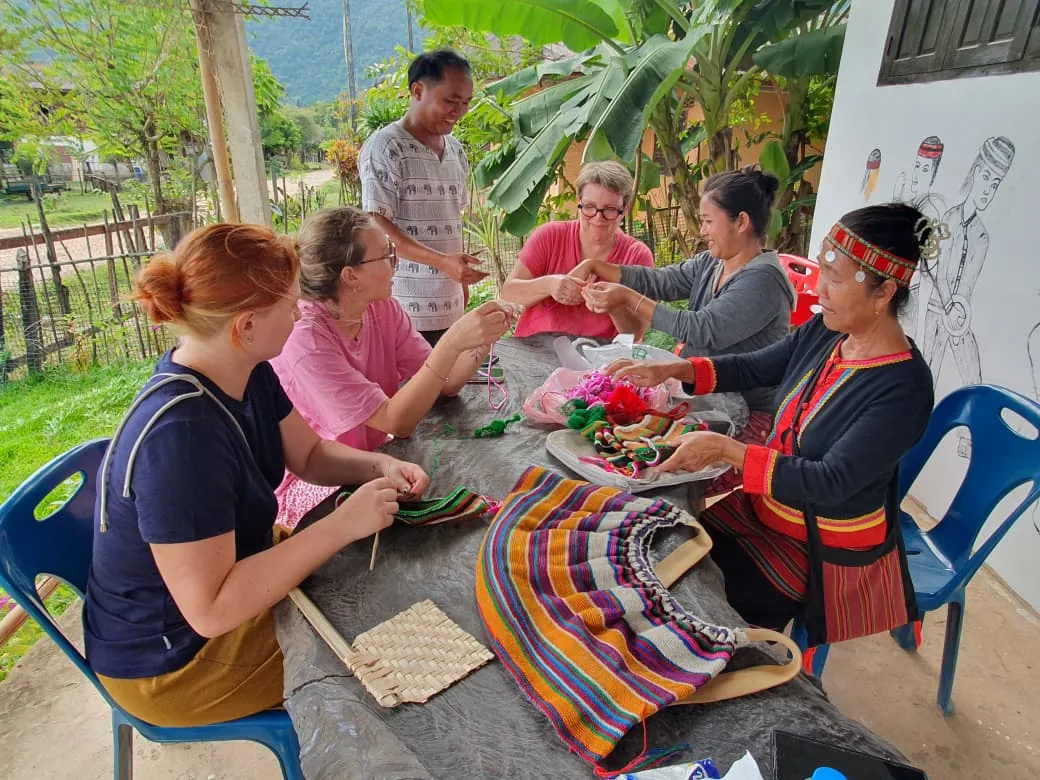 Travelers learning Khmu handicrafts with village women