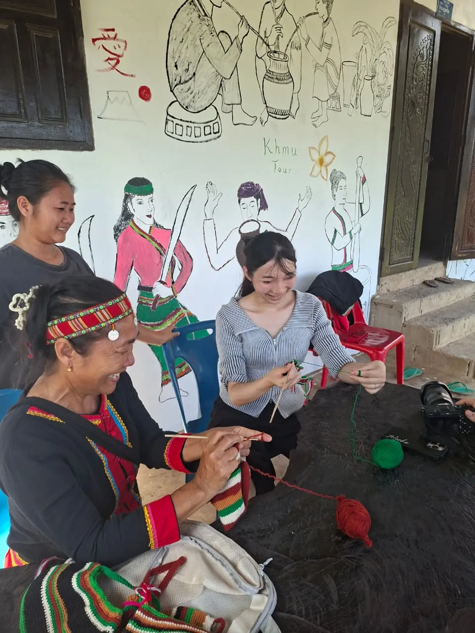 Khmu woman teaching a traveler traditional handicrafts