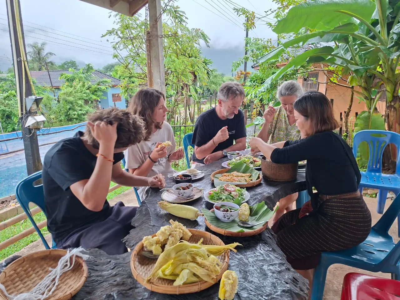 Travelers sharing a homemade Lao lunch in the village