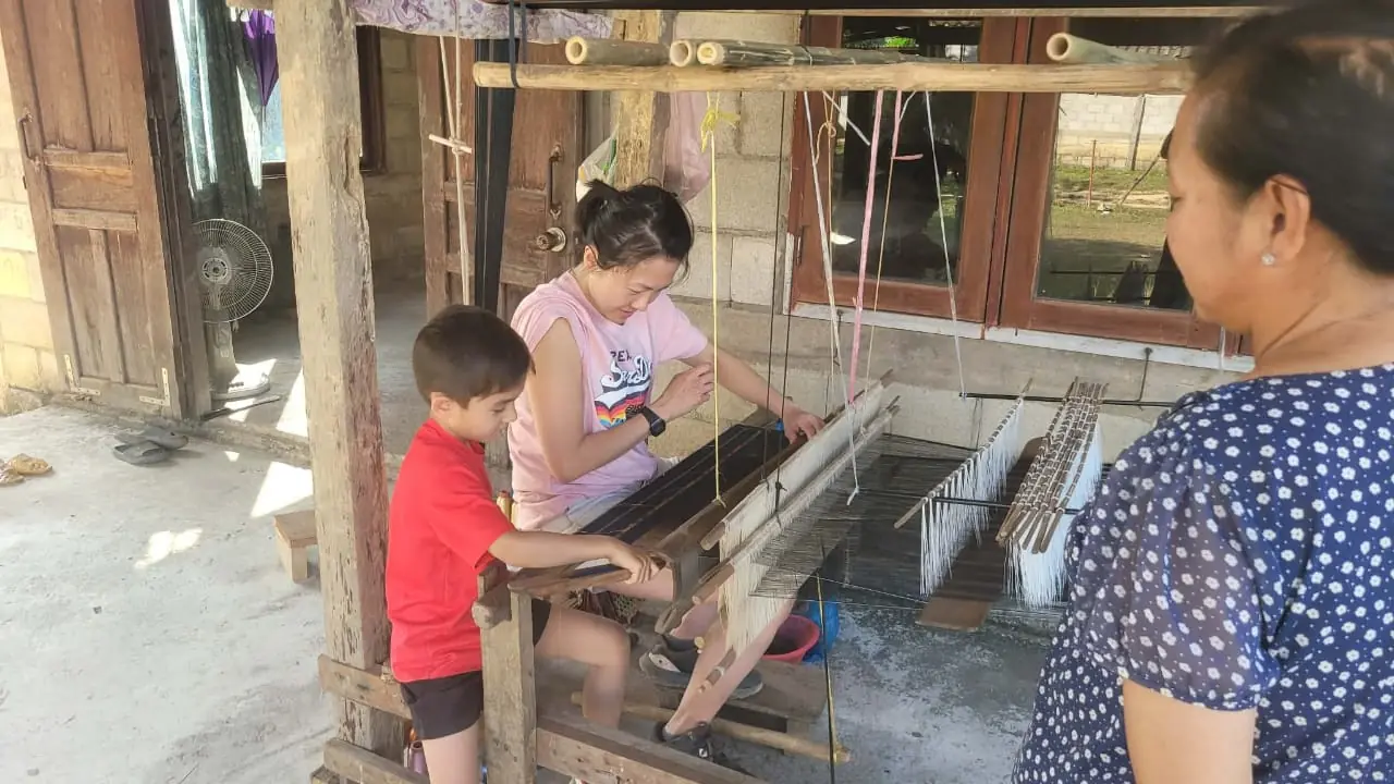 Mother and son trying the loom together